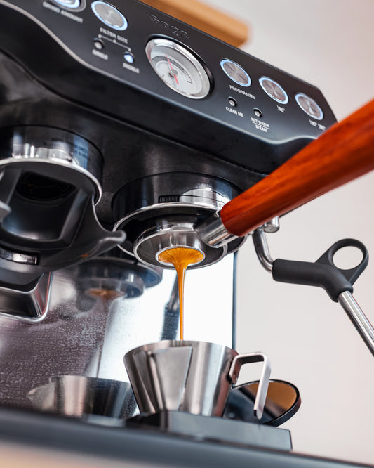 Espresso loopt uit een naked portafilter met convex filterbakje 54mm op een Sage Barista Express