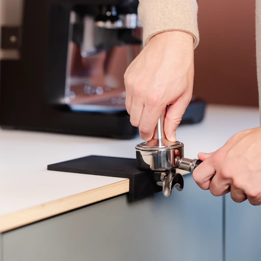 Black tamping mat with corner (small) from Barista-Essentials while tamping
