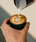 Latte art gift set for home baristas from Barista Essentials. The set contains freshly roasted coffee beans, a cappuccino cup and a milk jug